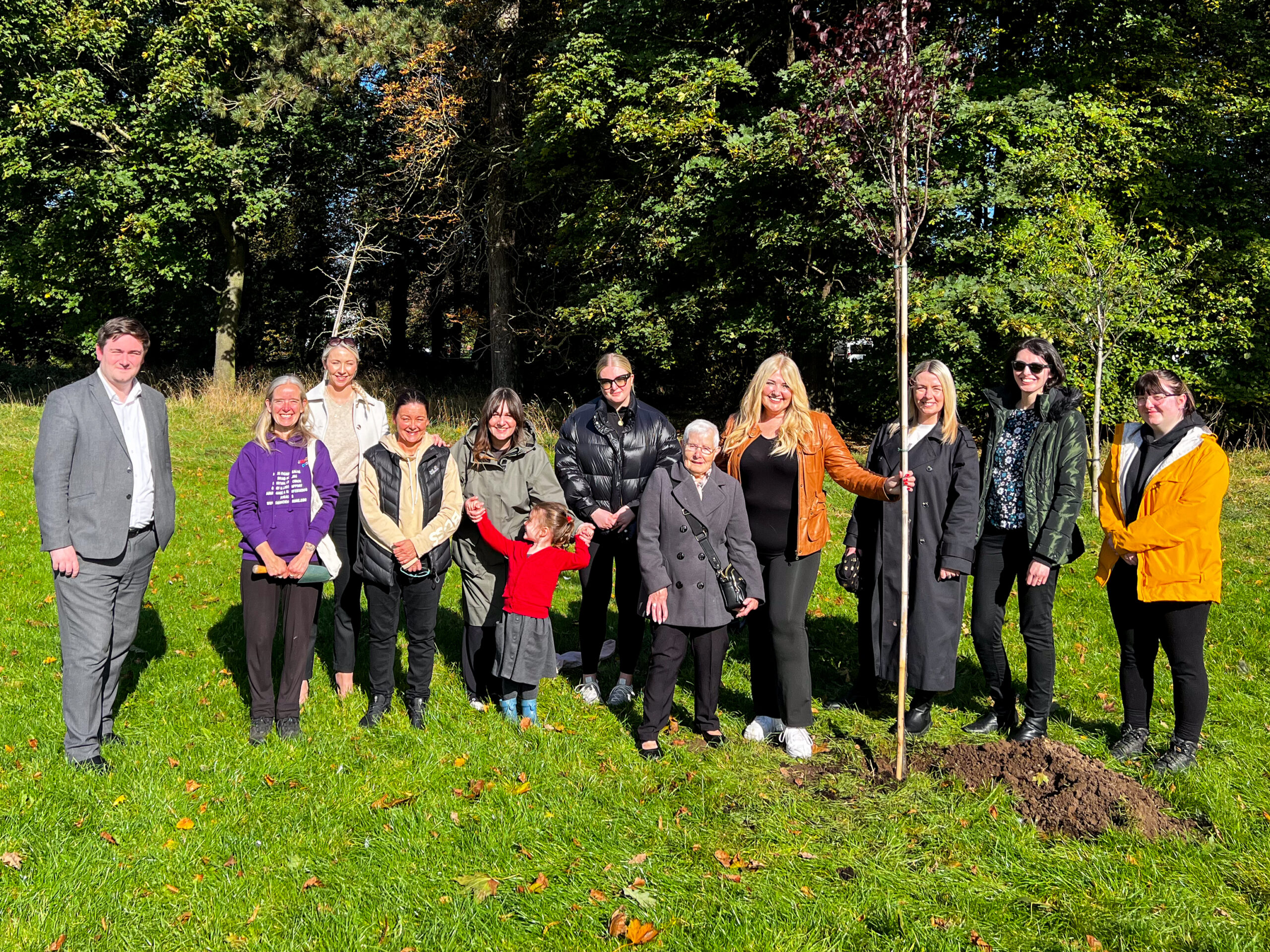 Group of people stood with Julie Burniston after planting her tree