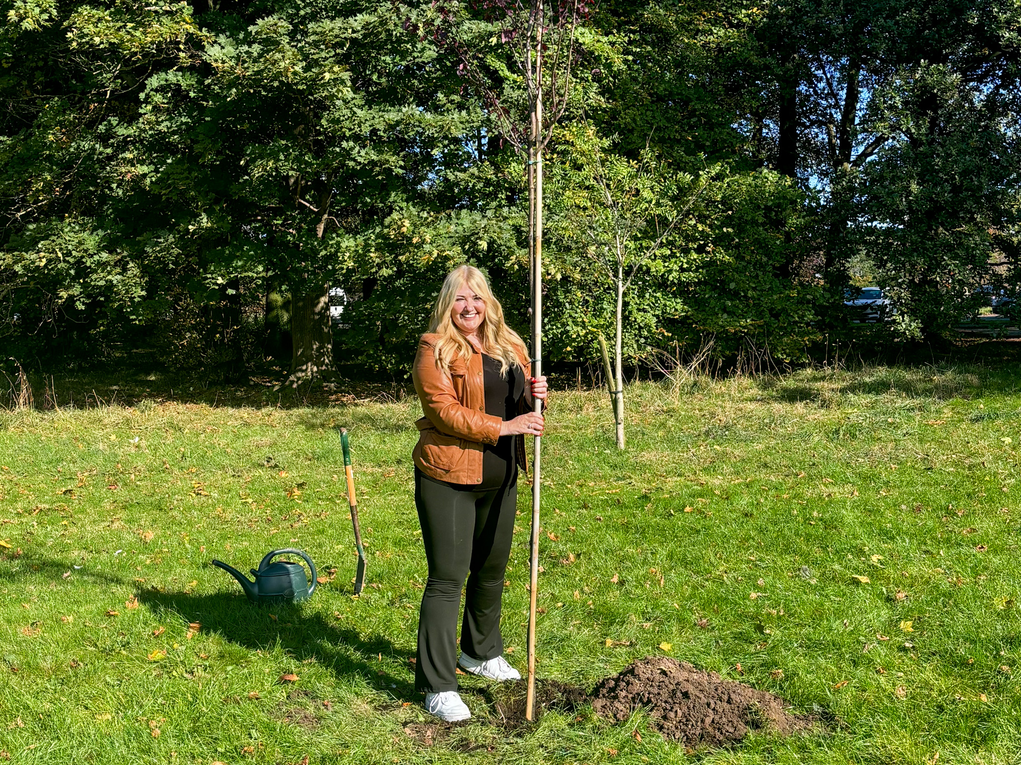 Julie Burniston stood with her hand holding her planted tree